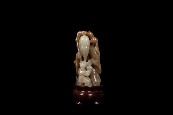 A CARVED TWO TONE JADE FIGURE OF SHOULAO