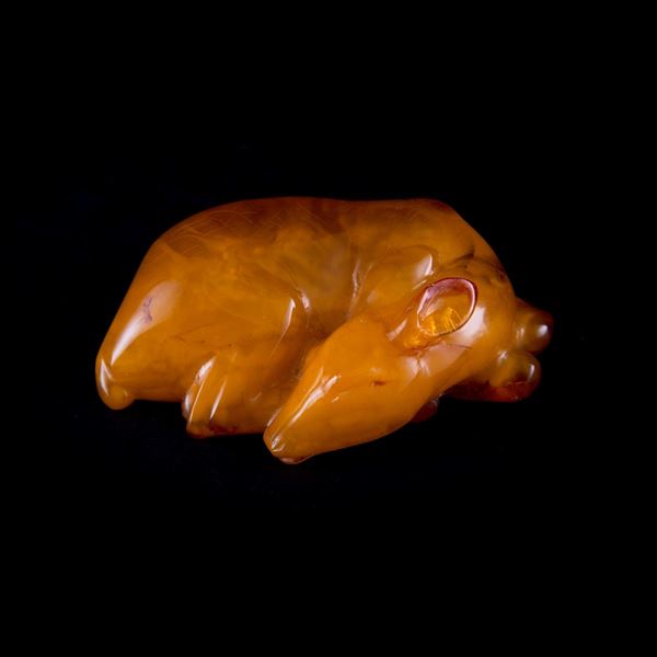 A RARE CARVED AMBER DEER IN RECUMBENT POSE