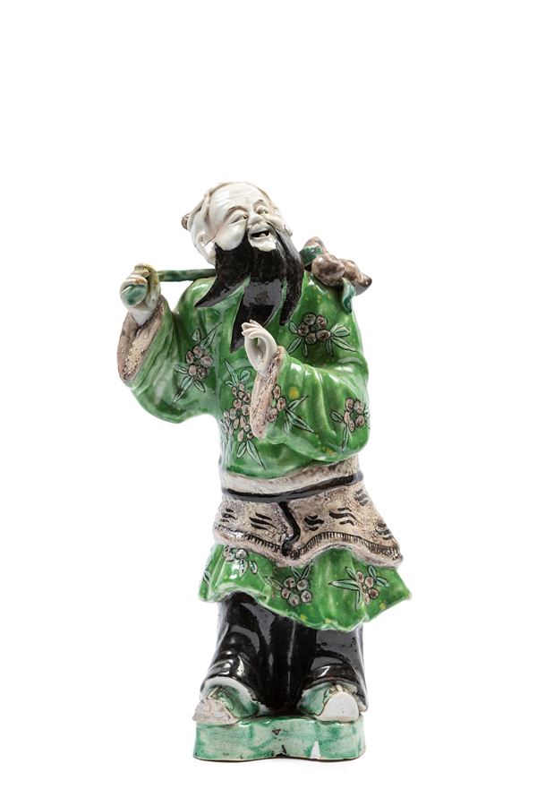 A FAMILLE VERTE PORCELAIN SCULTURE OF AN IMMORTAL