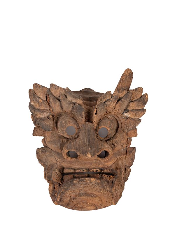 AN ANCIENT ORIENTAL WOODEN MASK DEPICTING A DEMON