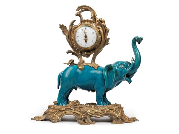 TABLE CLOCK WITH PORCELAIN ELEPHANT MOUNTED IN BRONZE