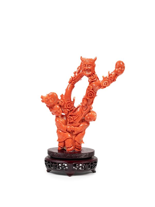 A CARVED RED MOMO CORAL SCULPTURE