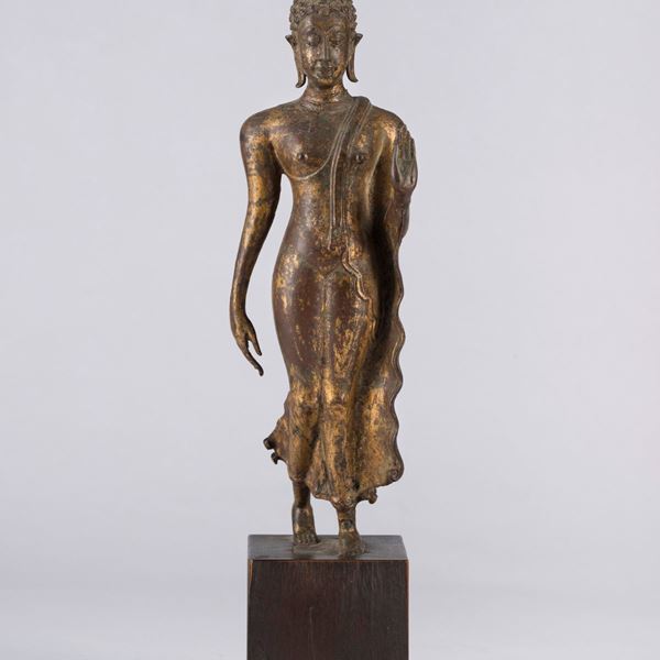 A BRONZE WALKING BUDDHA