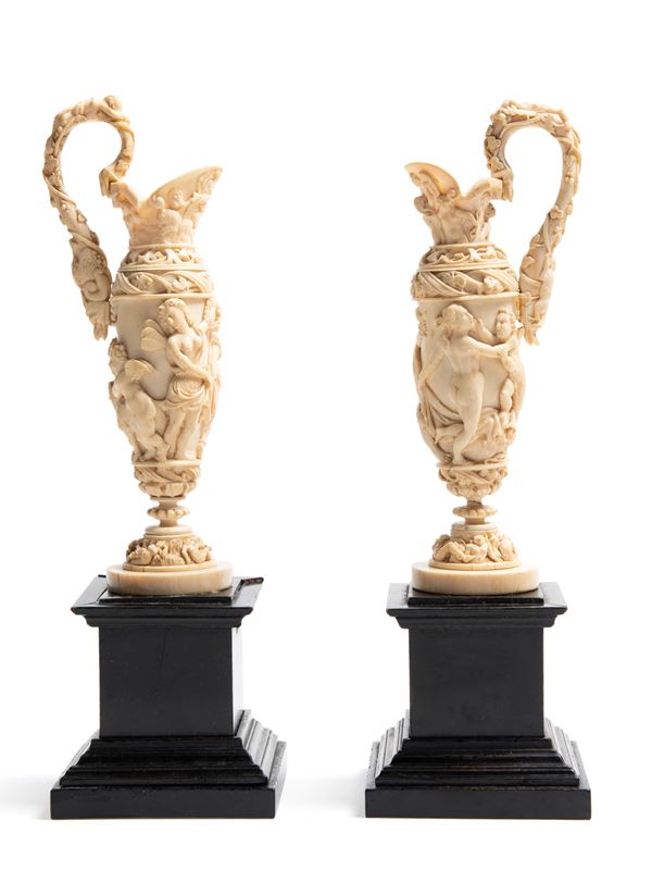 ☼A PAIR OF IVORY EWERS