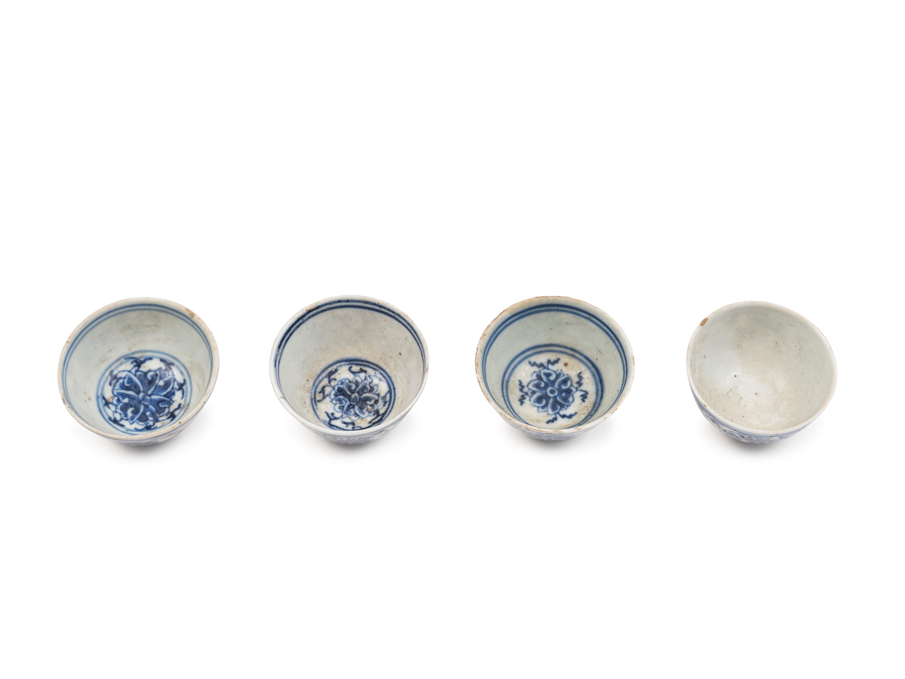 Cina (periodo Guangxu), Quattro tazzine in porcellana bianca e blu con decorazione a fiori di lot...