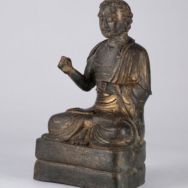A SEATED BRONZE FIGURE