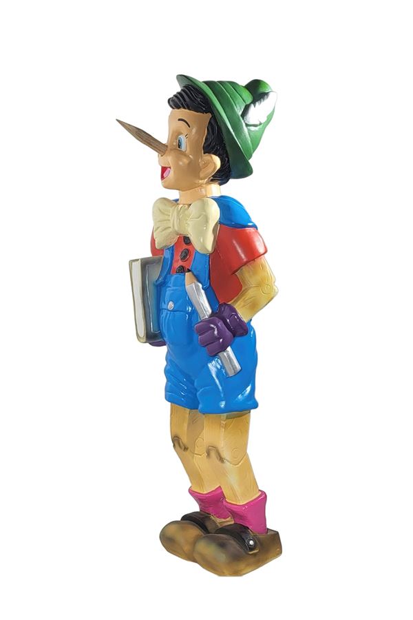 A PINOCCHIO FIGURE STATUE FROM THE ADVENTURES OF PINOCCHIO BY CARLO COLLODI