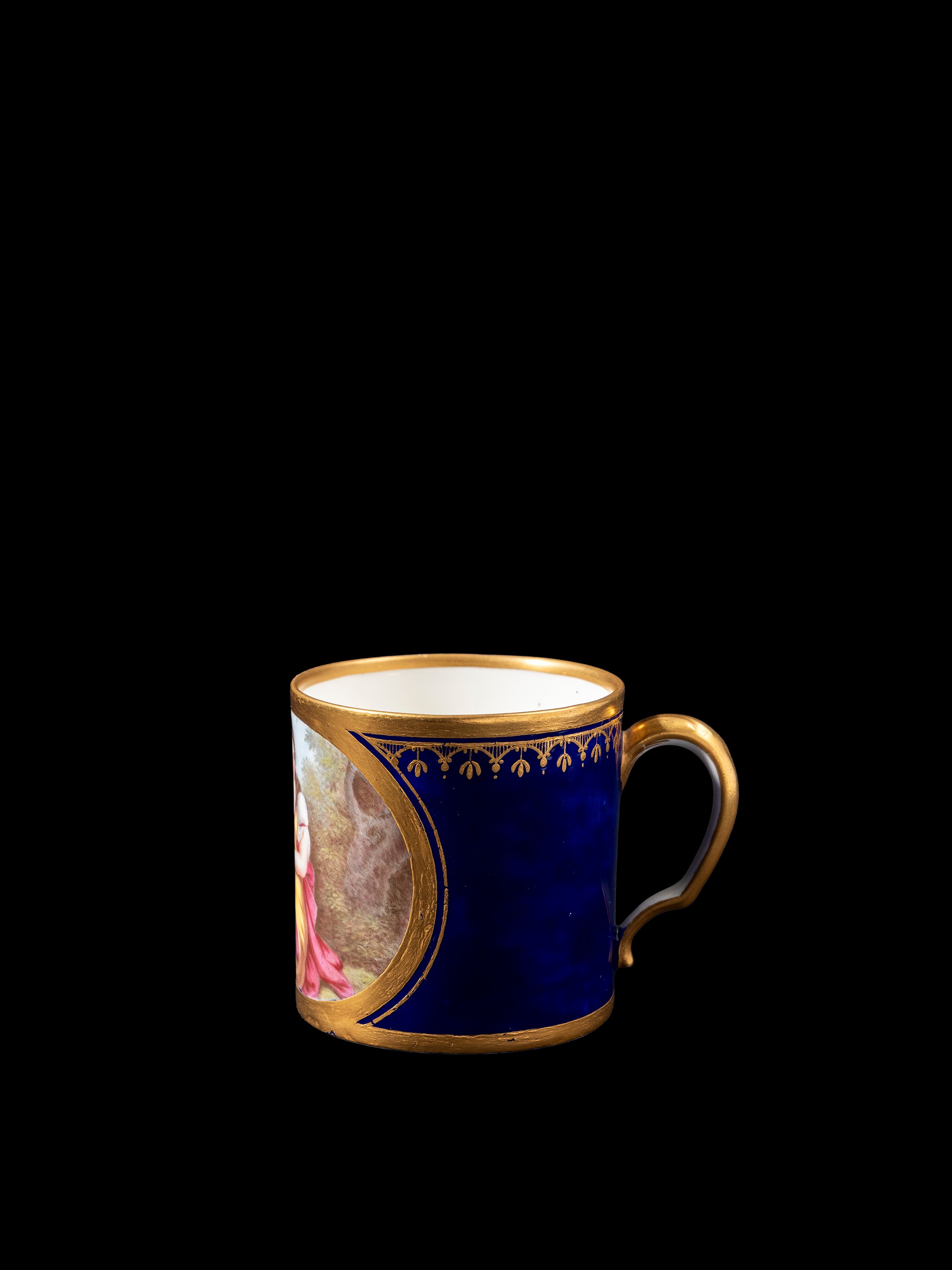 Sevres, Tazzina in porcellana blu cobalto con decorazioni in oro e scena con Cupido