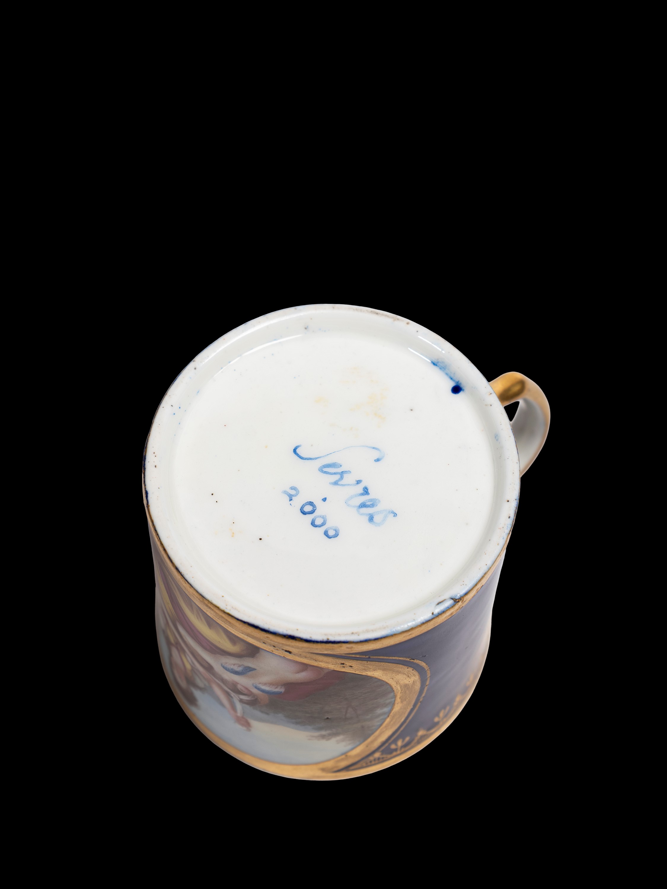 Sevres, Tazzina in porcellana blu cobalto con decorazioni in oro e scena con Cupido