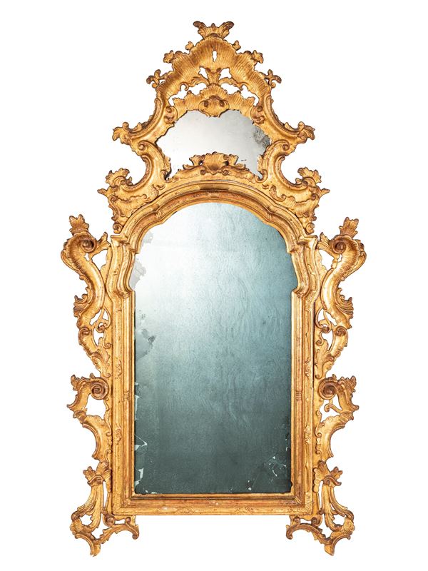A GILT AND CARVED LOUIS XV STYLE WOOD MIRROR