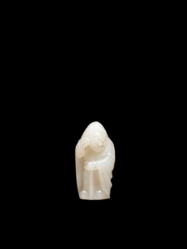 A SMALL WHITE JADE AND RUSSET CARVING OF A FIGURE