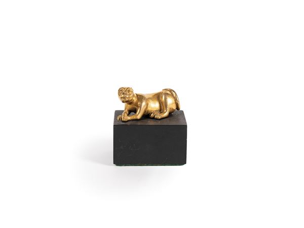 A SMALL GILT BRONZE FIGURE OF A DOG