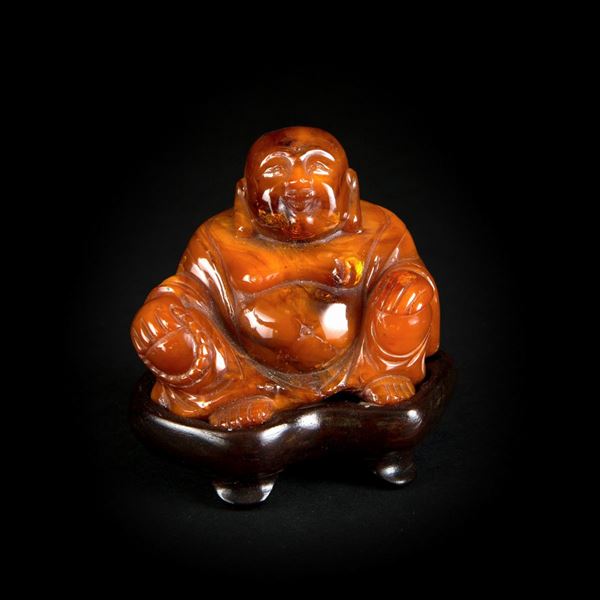 A SMALL AMBER BUDDHA
